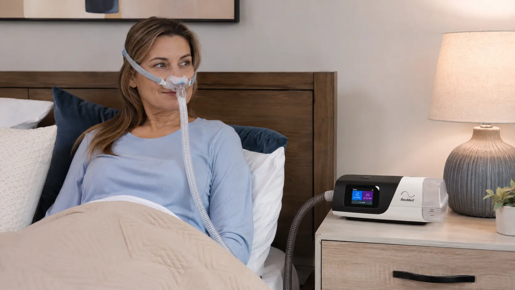 Femme utilisant un appareil CPAP ResMed AirSense S11 à domicile